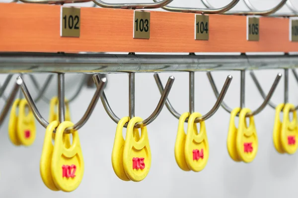 Nummer skrivet på etiketten hängande i checkroom. — Stockfoto