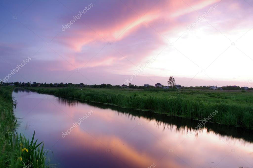 Spring landscape with yellow flower on hill and majestic sunset 