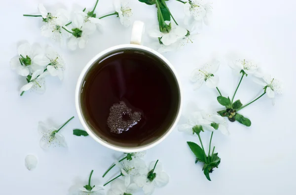 Chá com flores de cereja e ramos na mesa branca, vista superior Imagens De Bancos De Imagens Sem Royalties