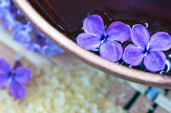 Flores en un tazón de color marrón con sal marina para SPA —  Fotos de Stock