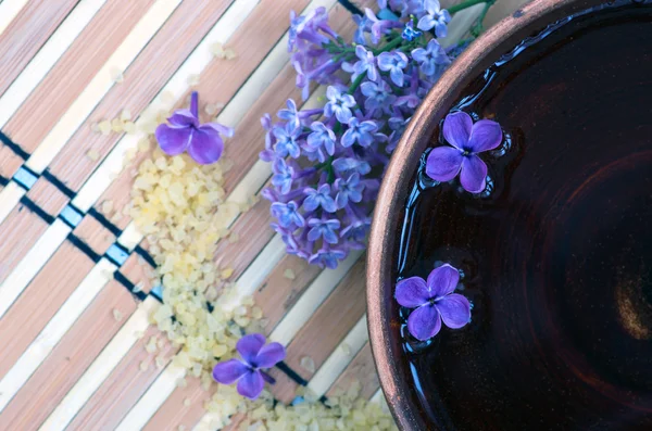 Flores en un tazón de color marrón con sal marina para SPA — Foto de Stock