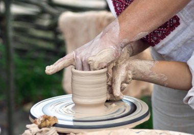 Bir çömlekçi elinde bir sürahi bir çömlek üzerinde yapmak çocuk yardım