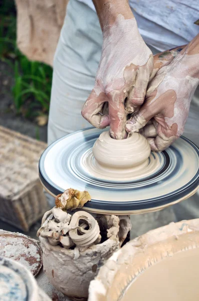 As mãos de um oleiro ajudam a criança a fazer um jarro em uma cerâmica — Fotografia de Stock