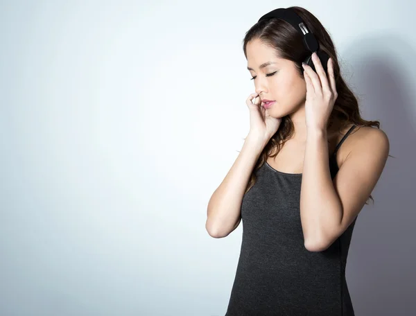 Bela jovem asiático mulher ouvindo música — Fotografia de Stock