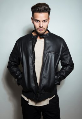 Yakışıklı genç adam günlük kıyafetlerle poz veriyor.