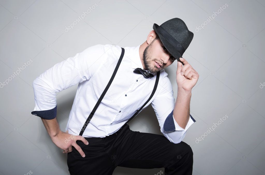 handsome young man in suit on grey background