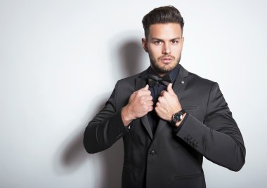 yakışıklı genç gri arka plan üzerinde takım elbiseli