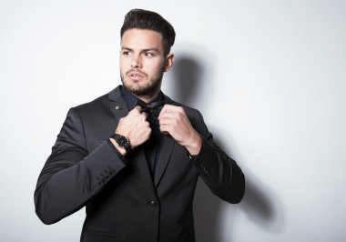 yakışıklı genç gri arka plan üzerinde takım elbiseli