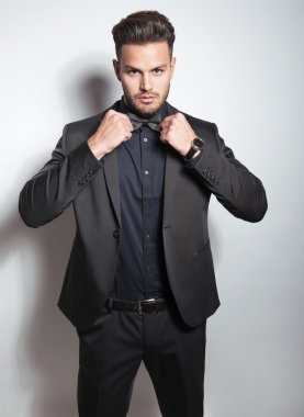 yakışıklı genç gri arka plan üzerinde takım elbiseli