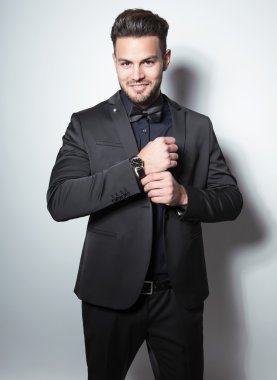 yakışıklı genç gri arka plan üzerinde takım elbiseli