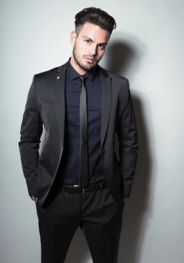 yakışıklı genç gri arka plan üzerinde takım elbiseli