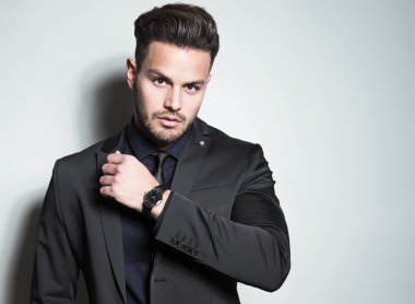 yakışıklı genç gri arka plan üzerinde takım elbiseli