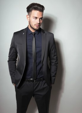 yakışıklı genç gri arka plan üzerinde takım elbiseli