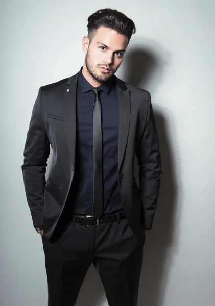 Handsome young man in suit on grey background — Stock Photo, Image