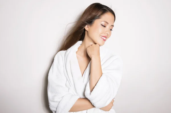 Vacker kvinna med felfri hud och långt hår poserar i badrock — Stockfoto