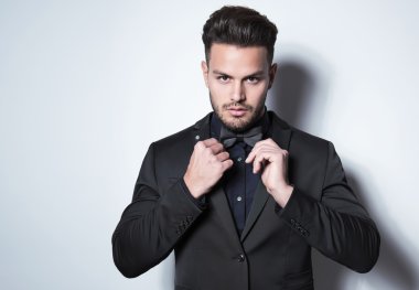 yakışıklı genç gri arka plan üzerinde takım elbiseli