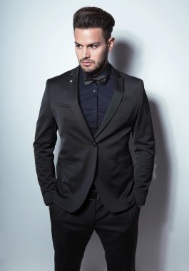 yakışıklı genç gri arka plan üzerinde takım elbiseli