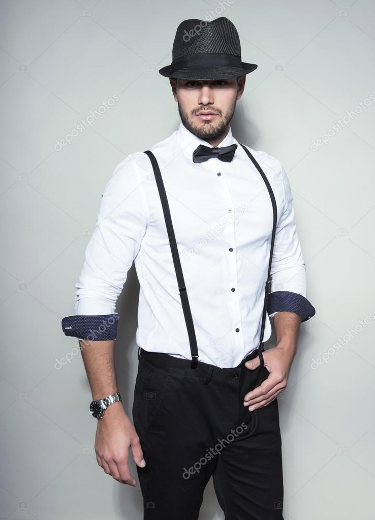 handsome young man in suit on grey background