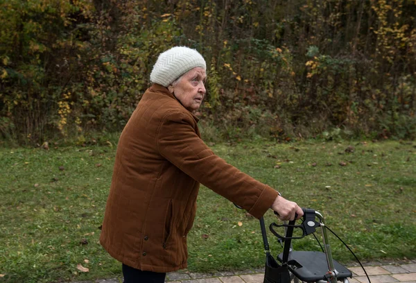 Пожилая Женщина Выходит Прогулку Осенью Помощью Ходунков Насладиться Свежим Воздухом — стоковое фото