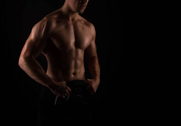 黒の背景に立って筋肉を持つハンサムな若いボディビルダー — ストック写真