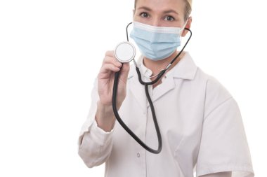 Beyaz üniformalı ve steteskoplu genç bir doktor, izole edilmiş arka planda maske takıyor.