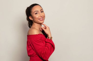 Gri arka planda uzun siyah saçlı ve doğal makyajlı güzel bir kadın. 