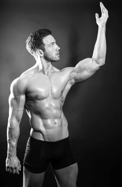 Bello giovane culturista mostrando del suo corpo e muscoli in forma — Foto Stock