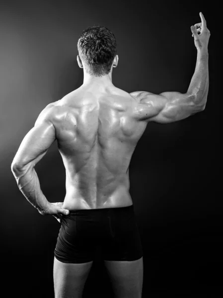 Beau jeune bodybuilder montrant son corps en forme et les muscles — Photo