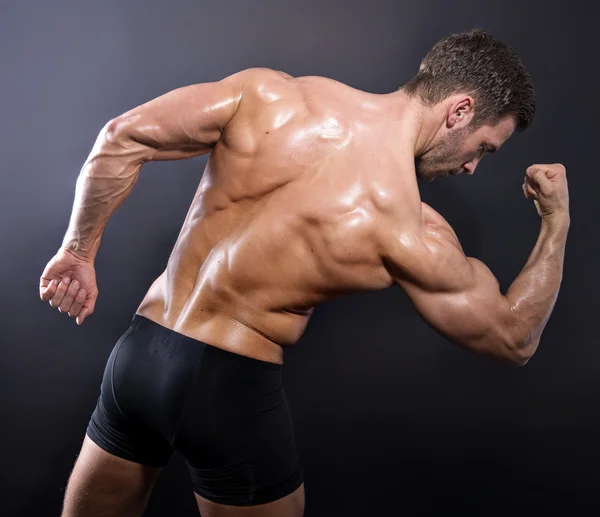 Knappe jonge bodybuilder vertoning van zijn passen lichaam en spieren — Stockfoto