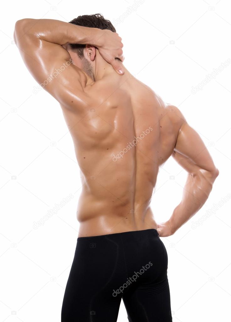 Handsome young bodybuilder showing of his fit body and muscles on isolated background