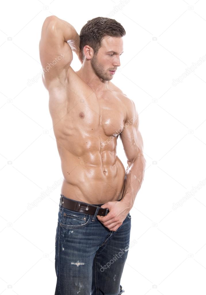 Handsome young bodybuilder with perfect and fit body showing off his muscles on isolated background