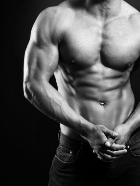 Kaslarına gösterilen yakışıklı kaslı genç vücut geliştirmeci