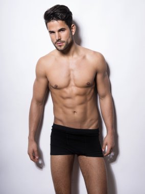 Onun kas gösterilen yakışıklı kaslı genç vücut geliştirmeci