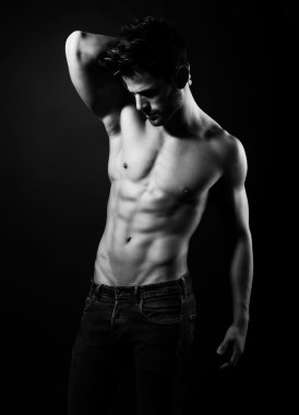 Onun kas gösterilen yakışıklı kaslı genç vücut geliştirmeci