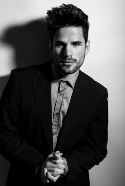 Gri arka planda takım elbiseli yakışıklı bir genç. İş adamı