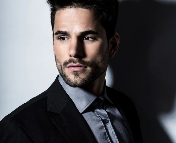 Joven guapo en traje sobre fondo gris. Hombre de negocios —  Fotos de Stock