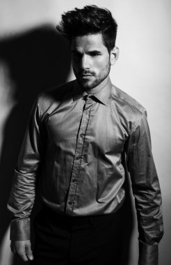 Gri arka planda takım elbiseli yakışıklı bir genç. İş adamı