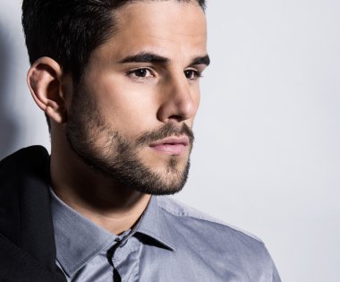 yakışıklı genç gri arka plan üzerinde takım elbiseli