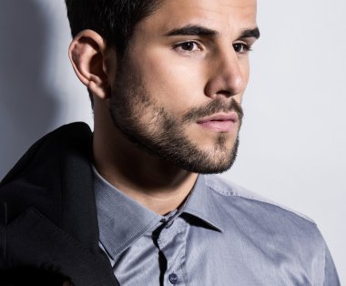 yakışıklı genç gri arka plan üzerinde takım elbiseli