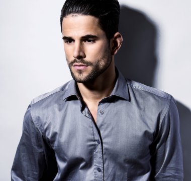 yakışıklı genç gri arka plan üzerinde takım elbiseli