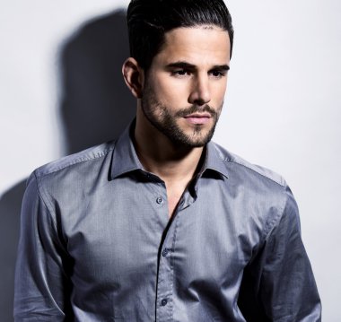 yakışıklı genç gri arka plan üzerinde takım elbiseli