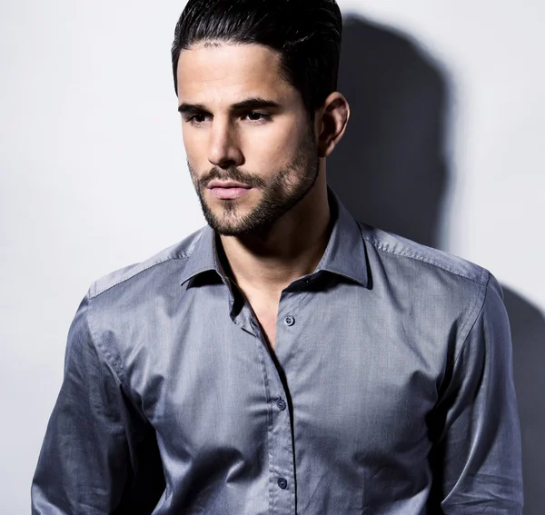 yakışıklı genç gri arka plan üzerinde takım elbiseli