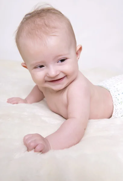 Bambino su coperta e sorridente — Foto Stock