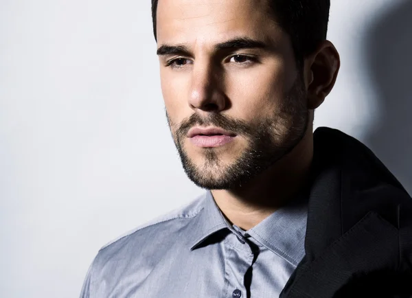 Handsome young man in suit on grey background — Stock Photo, Image