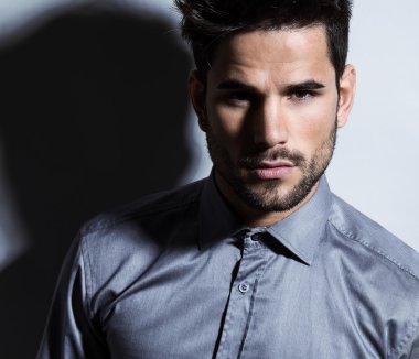 yakışıklı genç gri arka plan üzerinde takım elbiseli