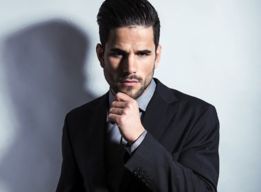 yakışıklı genç gri arka plan üzerinde takım elbiseli