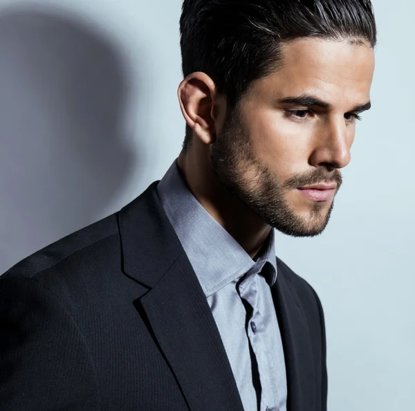 Handsome young man in suit on grey background — Stock Photo, Image