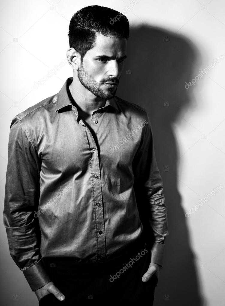 handsome young man in suit on grey background