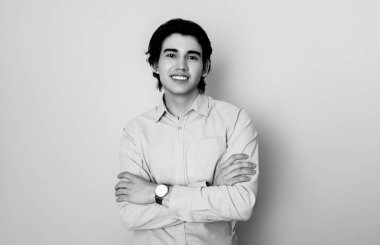 Metal kol saati takan, şık, rahat giyimli yakışıklı bir genç.