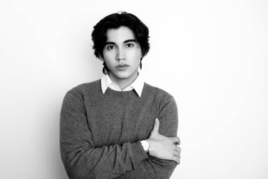 Metal kol saati takan, şık, rahat giyimli yakışıklı bir genç.